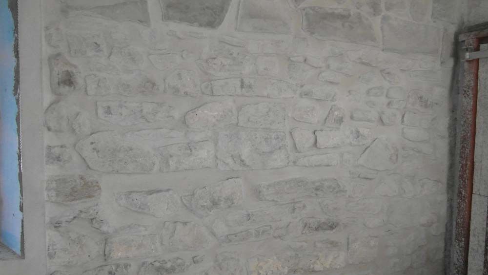 Mur en pierre rénové avec application d’enduit – Travaux de pose de parement et finitions AK Rénovation dans le Pays de Gex