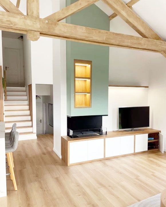  Aménagement intérieur d’un salon lumineux avec cheminée design, poutres apparentes et mobilier sur mesure – Entreprise AK Rénovation dans le Pays de Gex